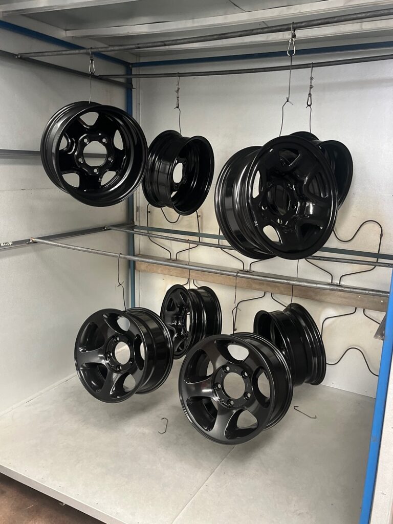 4 x steel rims and 4 x alloy rims coated in black powder coating cooling in oven